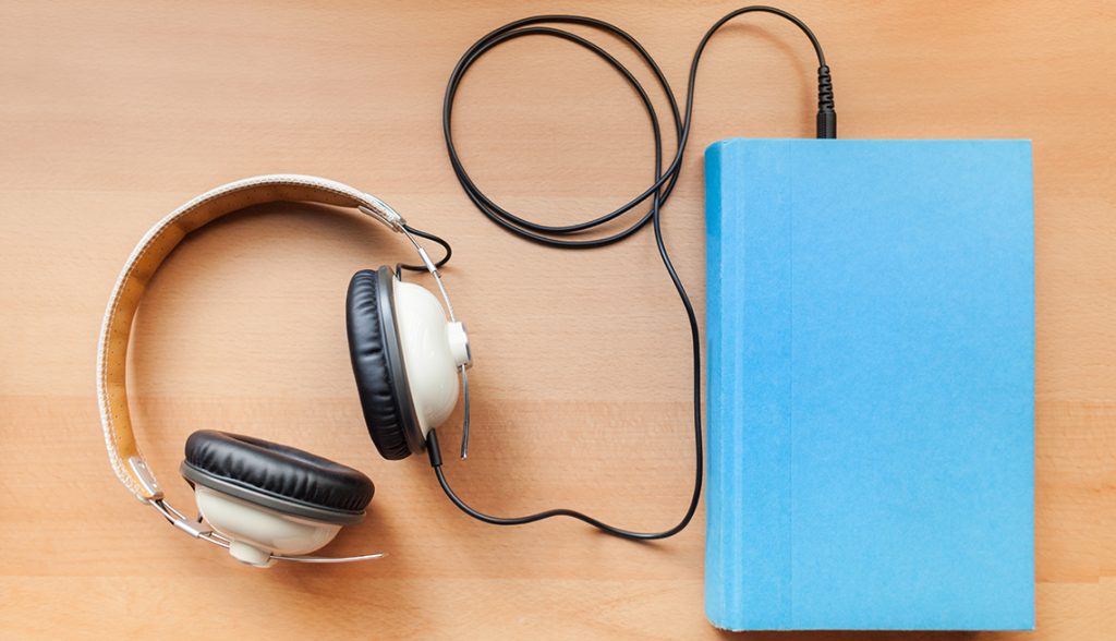Image of headphones connecting to a book