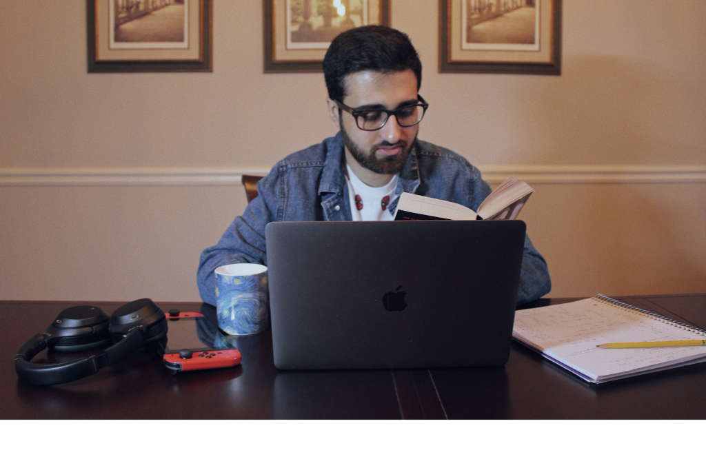 Muhammad Siddiq Website Featured Image--Working on laptop while reading